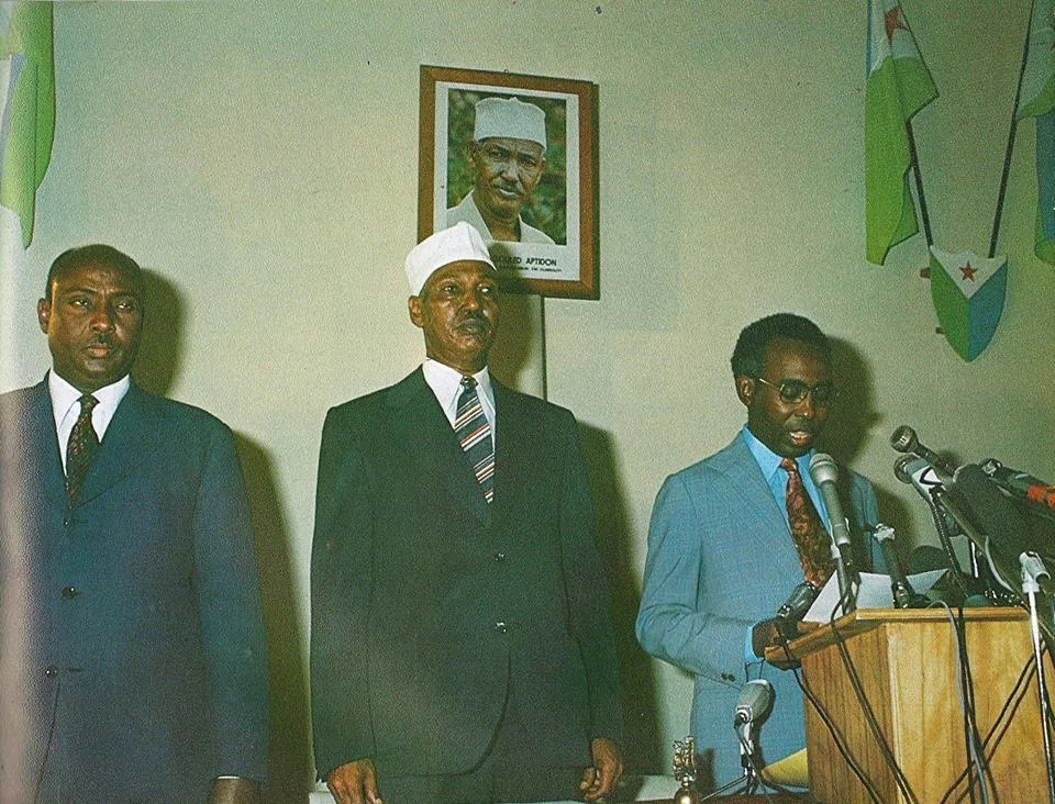 Ahmed Dini Ahmed lit la Déclaration d’indépendance au pupitre, devant les drapeaux de la nouvelle République, le 27 juin 1977